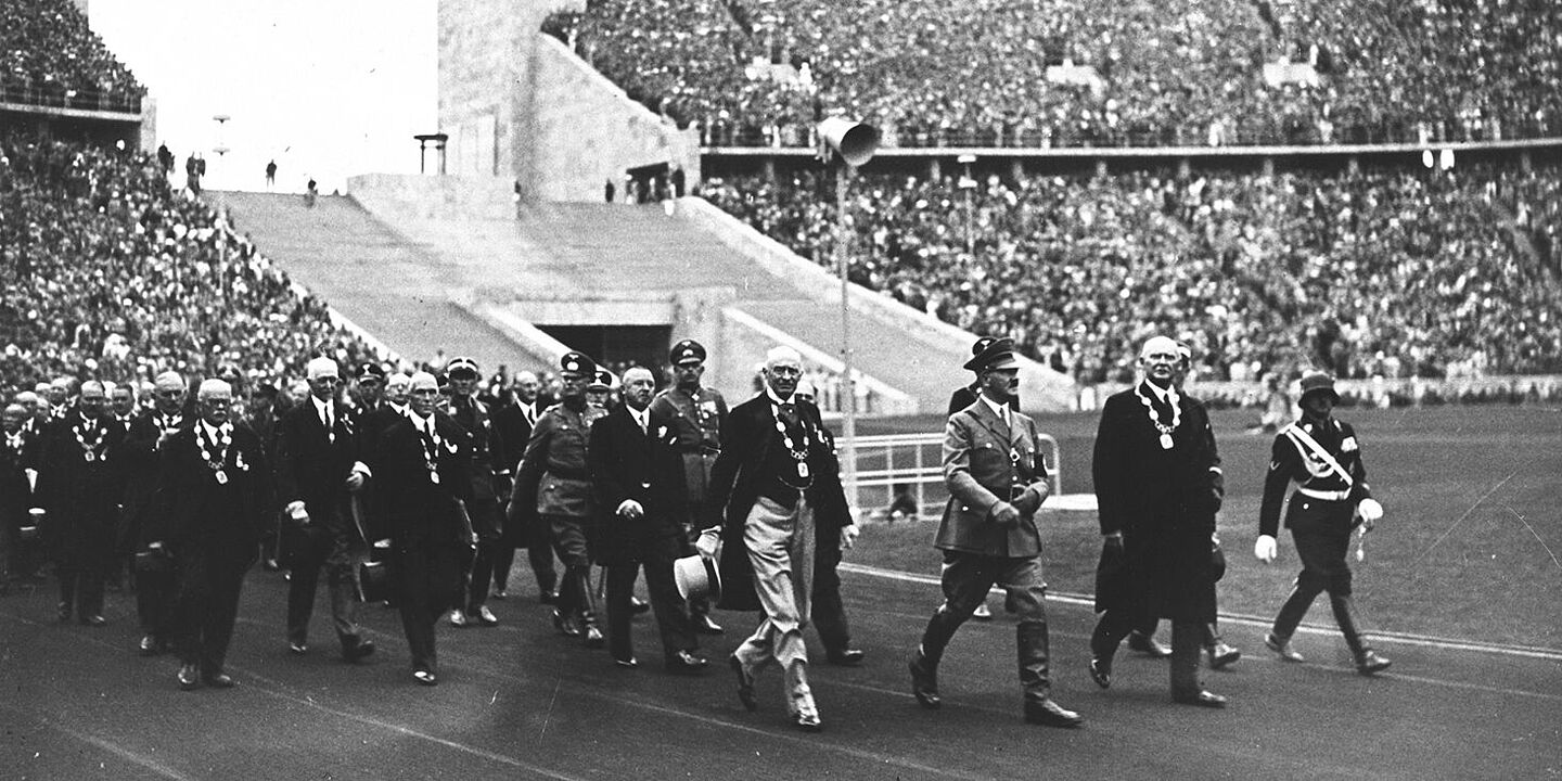 Adolf Hitler und Mitglieder des Internationalen Olympischen Komitees sowie des Organisationskomitees der Sommerspiele betreten das Olympiastadion über das Marathontor im West (Eröffnungsfeier der Olympischen Spiele am 1. August 1936) Adolf Hitler und Mitglieder des Internationalen Olympischen Komitees sowie des Organisationskomitees der Sommerspiele betreten das Olympiastadion über das Marathontor , Quelle:
BArch, 146-1976-033-17 / o. Ang.