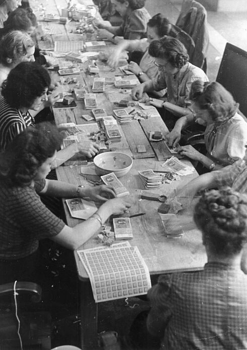 Aufkleben von Coupons anlässlich der Währungsreform 1948 Schwarz-Weiß-Aufnahme mit mehreren Frauen an einem Tisch, die Coupons auf Reichsmarkscheine aufkleben