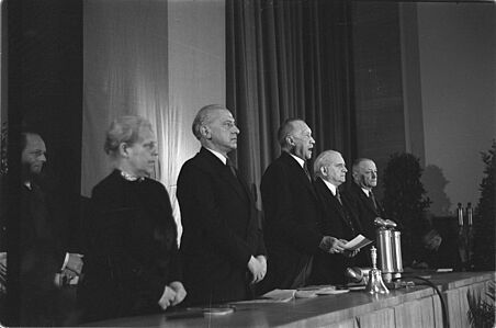 Verkündung des Grundgesetzes in Bonn am 23. Mai 1949 Konrad Adenauer steht mit einem Zettel in der Hand neben mehreren Personen und spricht.
