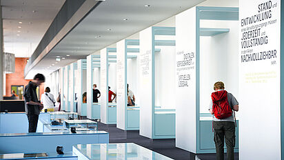 Blick in die Dauerausstellung „Geschichte in Geschichten“ Besucherinnen und Besucher betrachten Ausstellungstische und -vitrinen in der Ausstellung „Geschichte in Geschichten“., Quelle:
Bundesarchiv / Körner