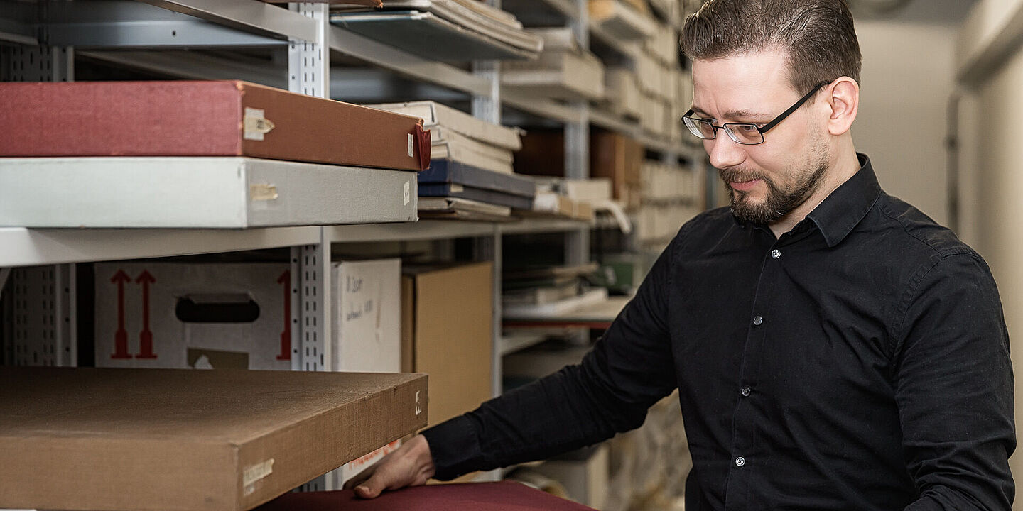 Arbeit im Archiv Ein Archivar des Bundesarchivs nimmt Archivalien aus einem Regal eines Magazins., Quelle:
BArch, B 198 Bild-2017-0301-031 / Nobel, Jürgen