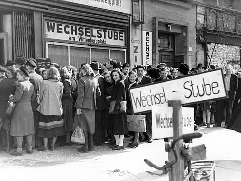 Währungsreform 1948/49: Menschenschlange vor einer Umtauschstelle am Wittenbergplatz, West-Berlin Schwarz-Weiß-Aufnahme einer Menschenschlange vor einem Geschäft mit der Beschriftung "Wechselstube am Wittenbergplatz"