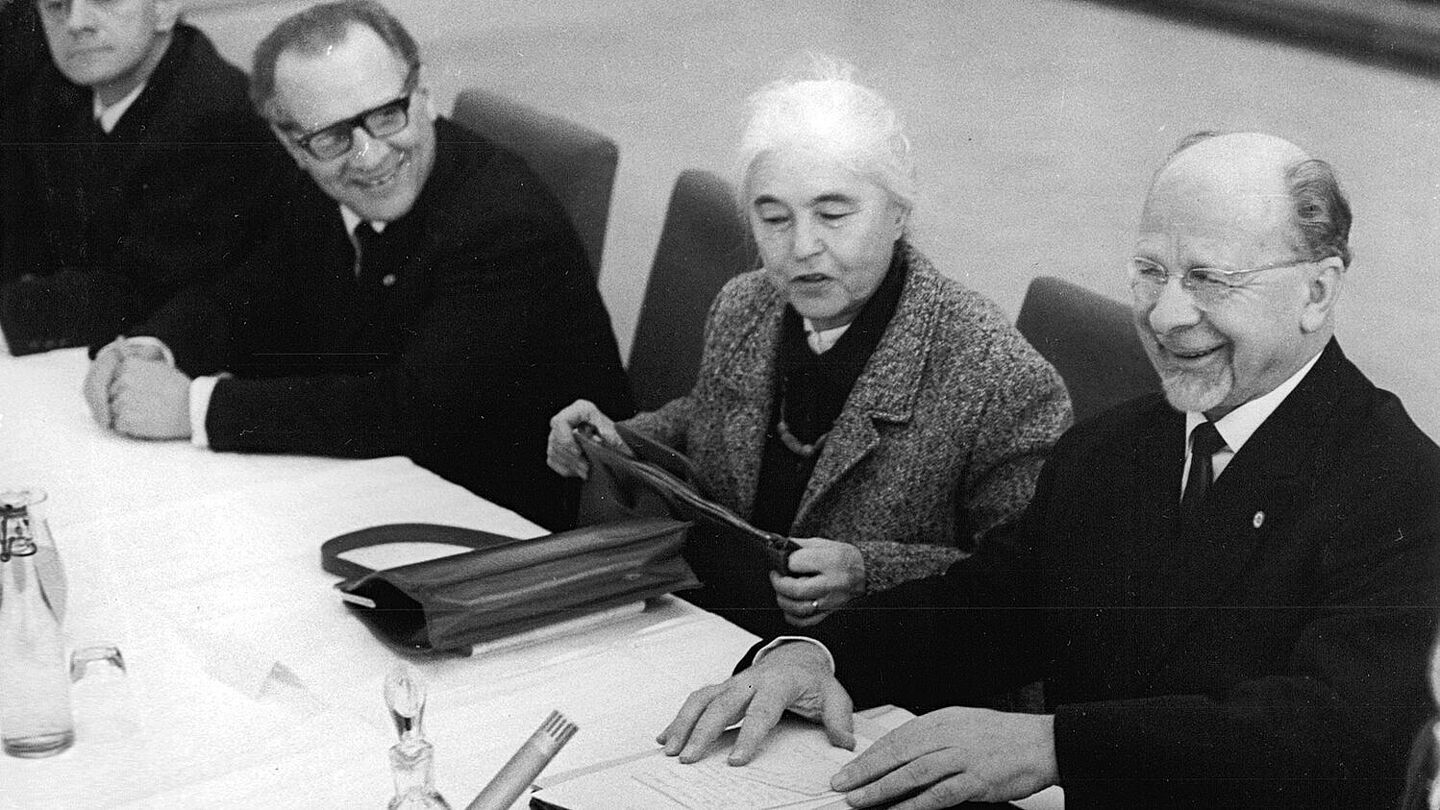 SED-Chef Walter Ulbricht empfängt am 25.11.1965 Schriftstellerinnen und Schriftsteller zum Gespräch. V.r.n.l.: Walter Ulbricht, Anna Seghers, Erich Honecker und Dieter Noll Schwarz-Weiß-Fotografie mit drei Herren und einer Frau in formeller Kleidung, lächelnd und an einem langen Tisch sitzend , Quelle:
BArch, Bild 183-D1125-0012-004 / Kohls, Ulrich